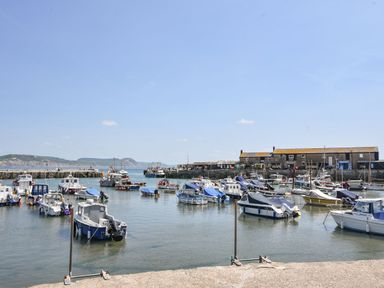 A harbor with boats and buildings at Coppingers Cottage in Polzeath