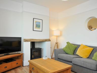 A living room with a sofa and television at The Porthole in Port Isaac