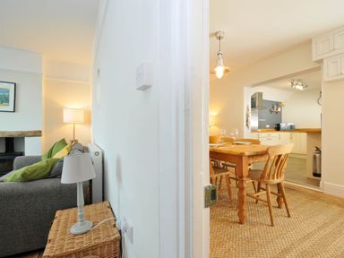 A living room with a sofa and a dining area at The Porthole in Port Isaac