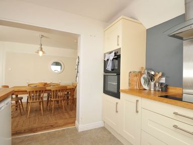 A kitchen with a doorway to the dining area at The Porthole in Port Isaac