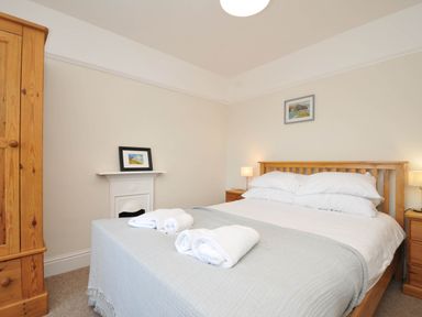 A bedroom with a bed and wardrobe at The Porthole in Port Isaac