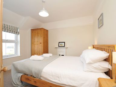 A bedroom with a bed and wardrobe at The Porthole in Port Isaac