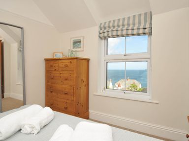 A bedroom with a dresser and a view of the sea at The Porthole Port Isaac