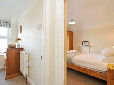 A bedroom with a bed and dresser at The Porthole in Port Isaac