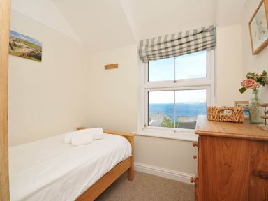 A bedroom with a bed and window view at The Porthole in Port Isaac