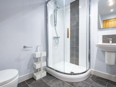 A bathroom with a shower enclosure a sink and toilet at The Hideaway Port Isaac