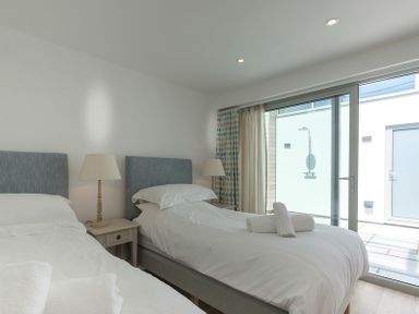A bedroom with two single beds and a nightstand between them at Point Break in Polzeath