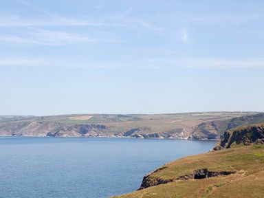 A coastal landscape with cliffs and a body of water at The Crows Nest in Port Isaac