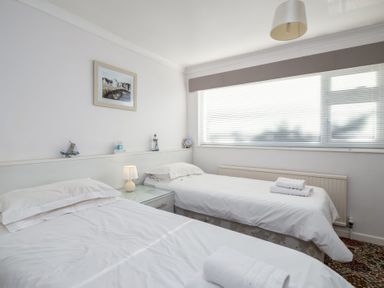 A bedroom with two single beds and a window at Hillview in Polzeath