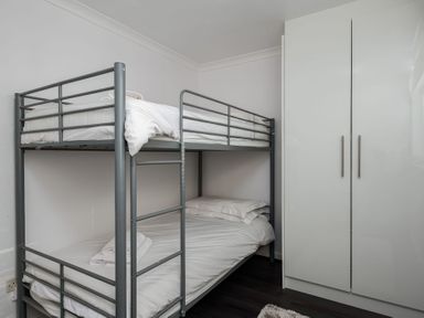 A bedroom with a bunk bed and a wardrobe at Hillview in Polzeath