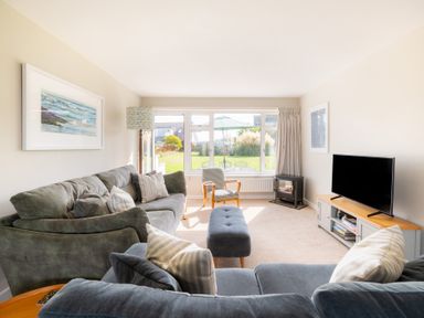 A living room with a sofa and television at Windyhill in Polzeath