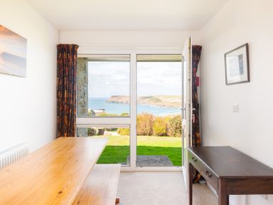 A dining room with a view of the sea at Windyhill in Polzeath