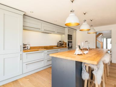 A kitchen with wooden countertops and stools along an island at Seastar in Rock