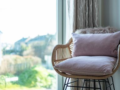 A chair with cushions beside a window with curtains at Seastar in Rock