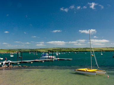 A small harbor with boats docked and people near the water at Artemis in Rock