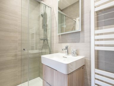 A bathroom with a shower enclosure a sink with a faucet and a mirror at Artemis Rock
