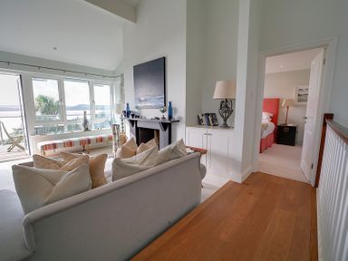 A living room with a sofa facing a fireplace and large windows showing an outdoor view at Camel Point in Rock