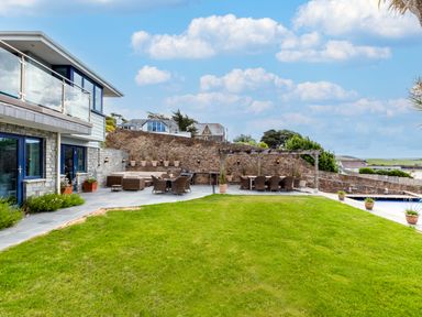 A backyard with patio furniture on stone tiles and a green lawn at Camel Point in Rock