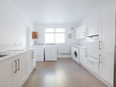 A utility room with washer and dryer under a window and white cabinets at Landers Field in Rock
