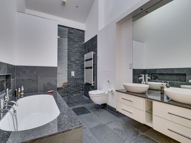 A bathroom with a bathtub shower toilet double sink and large mirror at Landers Field in Rock