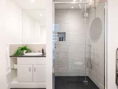 A bathroom with a sink and countertop next to a glass-enclosed shower at Landers Field in Rock