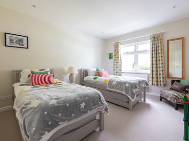 A bedroom with two single beds with star patterned blankets and colorful pillows at Landers Field in Rock