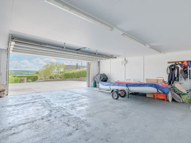 A garage with an open door showing a boat on a trailer wetsuits and storage boxes at Landers Field in Rock