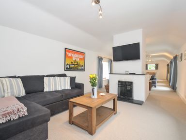 A living room with a sofa and coffee table at Orchard Cottage in Polzeath
