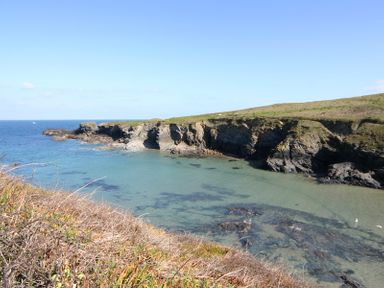 A coastal landscape with cliffs and clear water at Stop Tide in Port Isaac