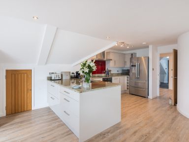 A kitchen with a countertop island with flowers and appliances at Upper Deck Rock