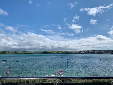 A view of a body of water with boats and a railing in the foreground at Upper Deck in Rock