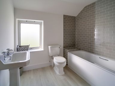 A bathroom with a pedestal sink a toilet a bathtub with tiled walls and a window Elmwood Port Isaac