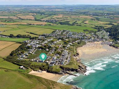 An aerial view of a coastal town with houses fields and beaches at Egloskerry in New Polzeath