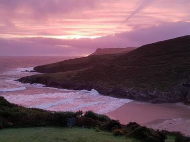 A coastal landscape with rocky cliffs and waves on a beach at Egloskerry in New Polzeath