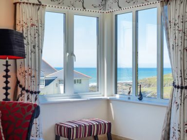 A corner window with striped bench and decorative items looking out to the sea at Egloskerry in New Polzeath