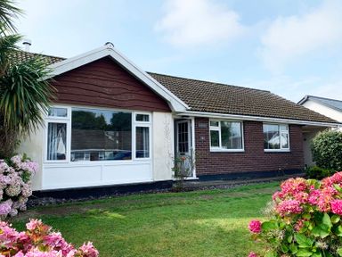A single-story house with a tiled roof and lawn with flowers in front at Greenaway 4 Rockhaven Gardens Rock