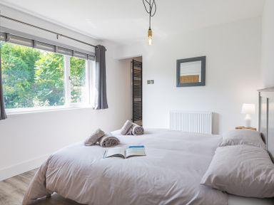 A bedroom with a bed a window with curtains a mirror and a lamp at Greenaway 4 Rockhaven Gardens Rock