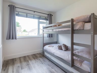 A bedroom with a bunk bed and window with curtains at Greenaway 4 Rockhaven Gardens in Rock