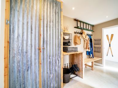 A mudroom with a bench coat hooks and a metallic cabinet at Seahaven in Port Isaac