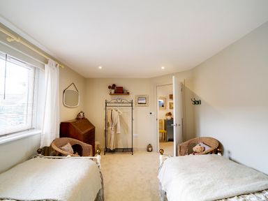 A bedroom with two single beds wicker chairs a window and a door at Seahaven in Port Isaac