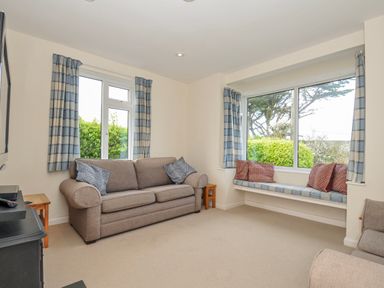 A living room with a sofa and a window at Hillcroft Bungalow Daymer Bay