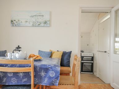 A dining room with a table set for tea at Hillcroft Bungalow Daymer Bay