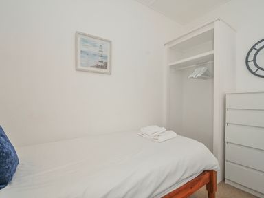 A bedroom with a bed and wardrobe at Hillcroft Bungalow Daymer Bay