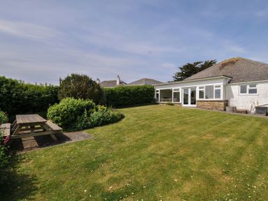 A garden with a picnic table and chairs at Hillcroft Bungalow Daymer Bay