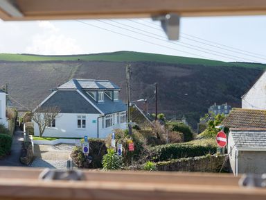 View of houses a road with traffic signs and green hills in the background at Sea Glimpses Port Isaac