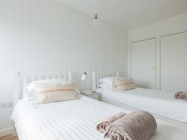 A bedroom with two single beds bedside table and a lamp at Westward 8 in Polzeath