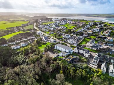 An aerial view of a coastal town with houses roads green fields and a sandy beach at Westward 8 Polzeath