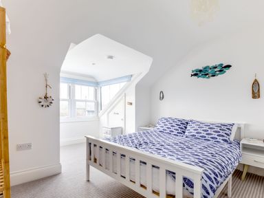 A bedroom with a bed and fish-themed bedding and decorations at Number 28 in Port Isaac