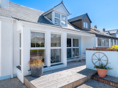 A porch with two large windows a small table with two chairs and potted plants at Number 28 in Port Isaac