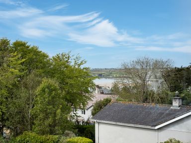 A view of trees houses a body of water and hills in the background at Flaad House in Rock